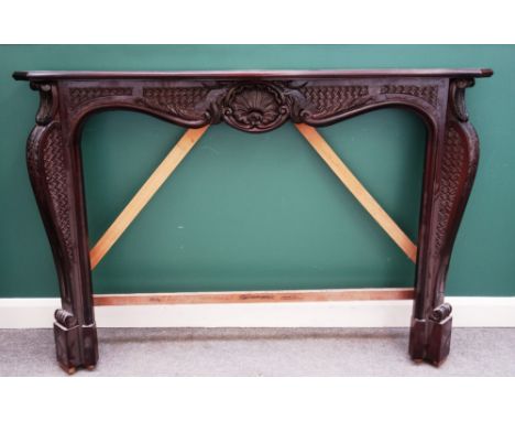 A mahogany fire surround of Louis XV style, with shell carved frieze and serpentine jambs, 166cm wide x 115cm high, the inter