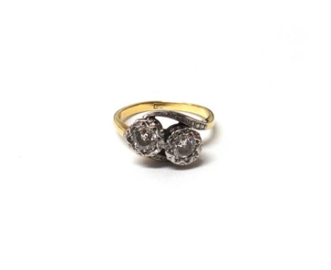 A gold and diamond set two stone ring, mounted with circular cut diamonds, in a crossover design, detailed 18 CT, ring size M