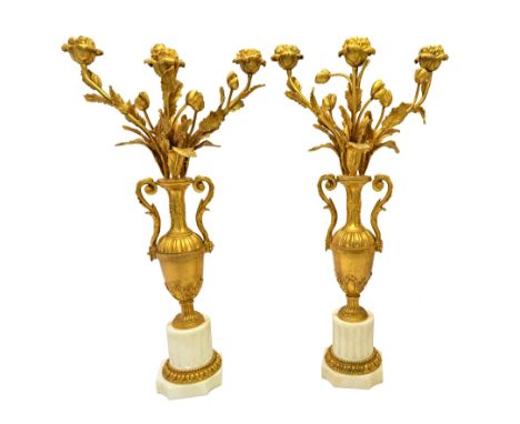 A pair of French ormolu and white marble three light candelabra of Louis XVI style, late 19th century,the central two handled