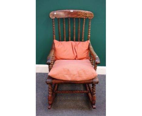 A Victorian faux rosewood rocking chair with bobbin turned decoration, 57cm wide x 105cm high.