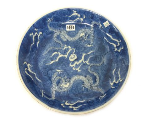 A Chinese blue and white dish, Kangxi, painted with two ferocious dragons encircling a flaming pearl, 34.5cm.diameter.