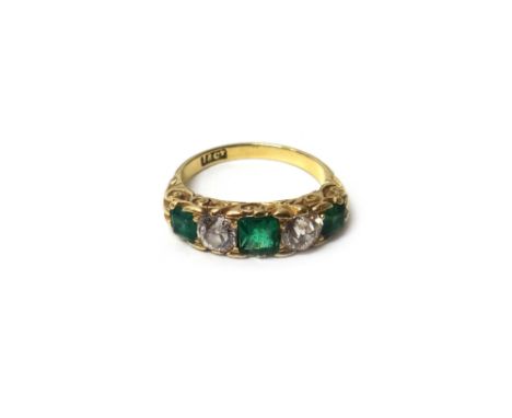 A gold, emerald and diamond five stone ring, mounted with three emeralds and with two cushion shaped diamonds mounted at inte