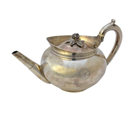 A George III silver teapot, of circular form, the detachable lid having a flower spray finial, crest and motto engraved, make