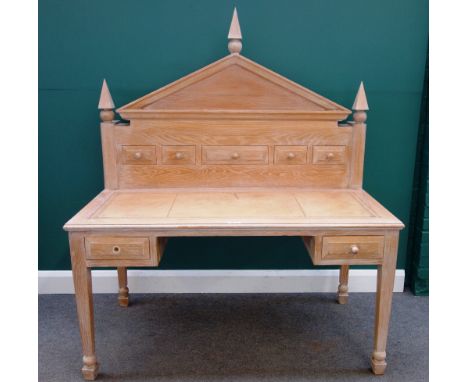 A 20th century limed oak desk with fitted architectural superstructure over pair of drawers on tapering square supports, 137c