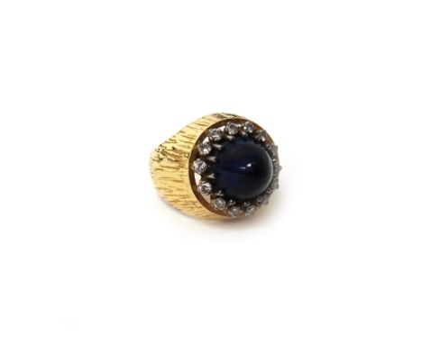 A European gold, diamond and cabochon blue stained jasper dress ring, the central cabochon blue stained jasper mounted with a