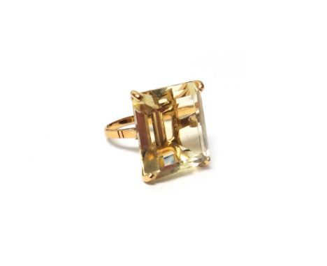 A gold ring, claw set with a rectangular step cut citrine, ring size M, with a case.