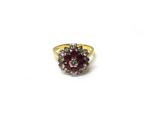 A gold, diamond and ruby cluster ring, claw set with the circular cut diamond at the centre, in a surround of six circular cu