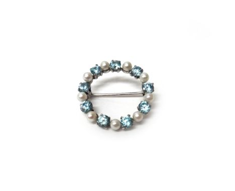 A 9ct white gold, blue zircon and cultured pearl set circular brooch, claw set with circular cut blue zircons, alternating wi