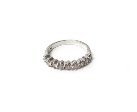 A white gold and diamond nine stone half hoop eternity ring, mounted with a row of circular cut diamonds, detailed 750, ring 