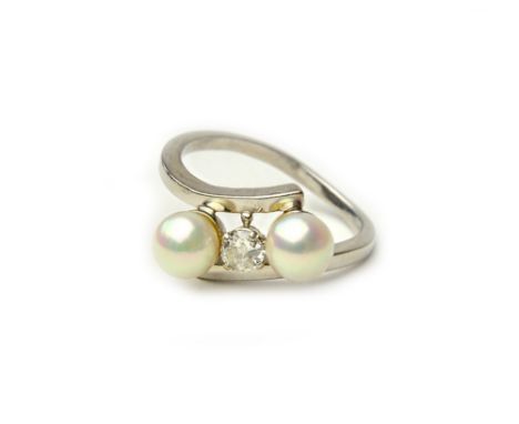 A white gold, diamond and cultured pearl ring, claw set with the circular cut diamond at the centre, between two cultured pea