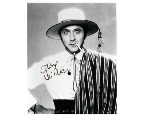 WILDER GENE: (1933-2016) American comedy actor. Signed 8 x 10 photograph of Wilder standing in a half-length pose, smoking a 