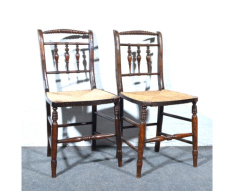 Pair of rush seat kitchen chairs, bobbin top rail, spindle backs, turned and ringed legs.