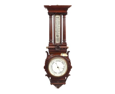 An Edwardian aneroid barometer and thermometer in a carved oak case, 92cms high.