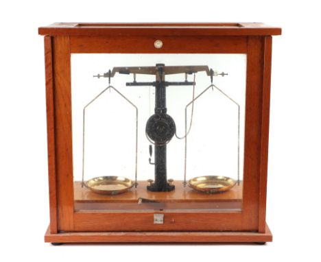 A set of chemist's scales in a glazed oak case.