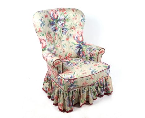 A Victorian style button back armchair on turned front supports.