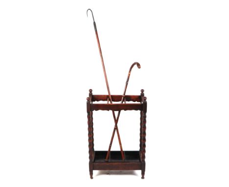 An oak three-division stick stand on bobbin turned supports; together with a bamboo walking stick and a bamboo handled fishin