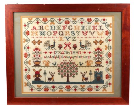 A 19th century style cross stitch sampler with alphabet, numbers and animals within a wavy foliate border, 40 by 34cms.