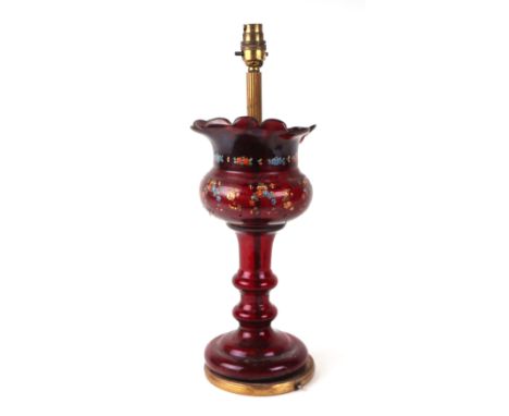 An early 20th century ruby glass table lamp decorated with flowers, 45cms high.