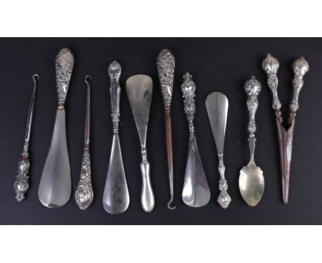 A quantity of silver handled shoe horns, button hooks and a pair of similar glove stretchers.