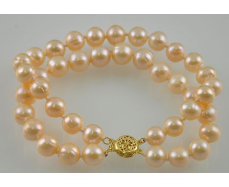 An 8-10mm natural pink pearl two row bracelet with a 14ct gold clasp