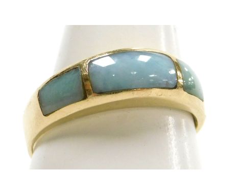 A three stone jade set ring, in yellow metal, stamped 14K, size O, 3.2g. 