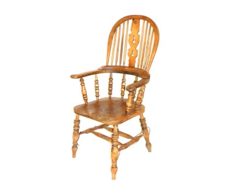 A 19thC oak and elm Windsor chair, with a carved splat, scrolling arms, raised on spindles, solid saddle seat, raised on turn