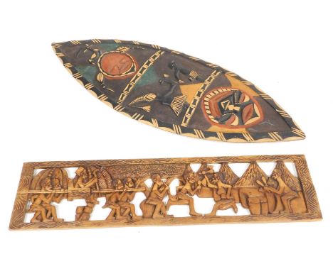 A African tribal shield, carved with masks, figures and an antelope, 142cm high, and tribal panel, of a chieftain being carri