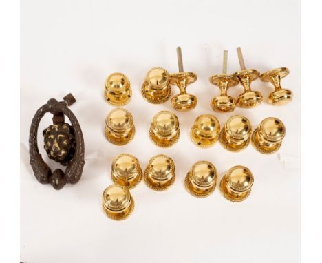 Eight pairs of matching brass doorknobs and a brass door knocker with mask head centre