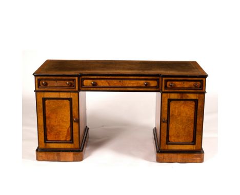 A breakfront kneehole desk by Lamb of Manchester, in burr elm with ebonised banding, the pedestals both with cupboards, three