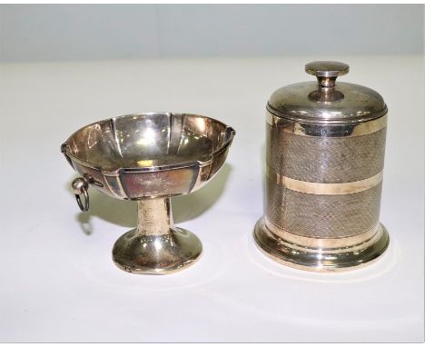 A silver cigarette dispenser, JC Ltd., Birmingham 1937, of cylinder form with engine turned decoration, 11.5cm high and a foo
