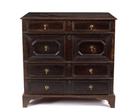 A 17th Century style oak chest of four long drawers with geometric mouldings to the fronts, on bracket feet, 102cm wide