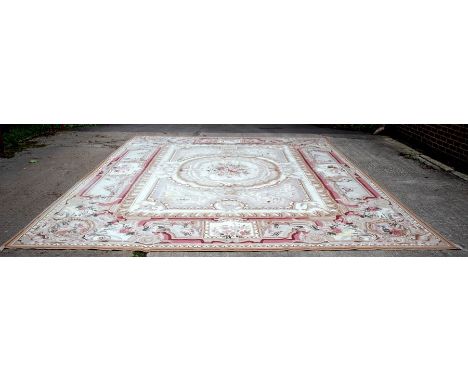 A large Aubusson style carpet, the central oval cartouche containing flowers within conforming borders, 550cm x 394cm CONDITI