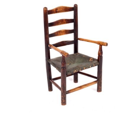 A child's ladder back chair with rush seat and turned legs