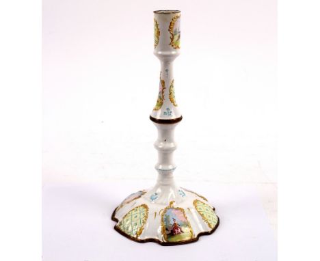 A Bilston enamel candlestick with baluster column enamelled reserves, decorated pastoral scenes, 26.5cm high