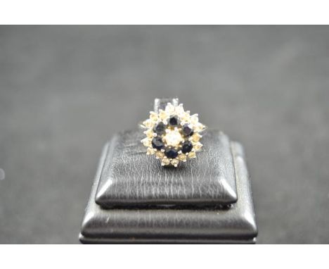 An 18ct white gold ring with diamonds and sapphires in floral setting - size K.