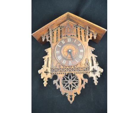 A late 19th/early 20th Century Bavarian carved oak cased cuckoo clock, Roman numerals to dial, gothic style pendulum, two iro