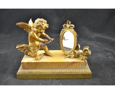 After Jean Antoine Houdon (1741-1828) -  a gilt metal figure of cupid looking into a mirror, on marble plinth, all mounted on