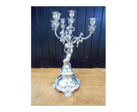 A mid Victorian silver four light candelabrum, R & S Garrard & Co, Panton St. London, cherub support, foliate & garland decor