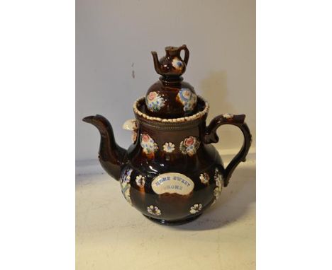 A Measham bargeware treacle glazed teapot with applied spriggs, 'teapot' domed lid, bearing the motto 'Home Sweet Home' - H33