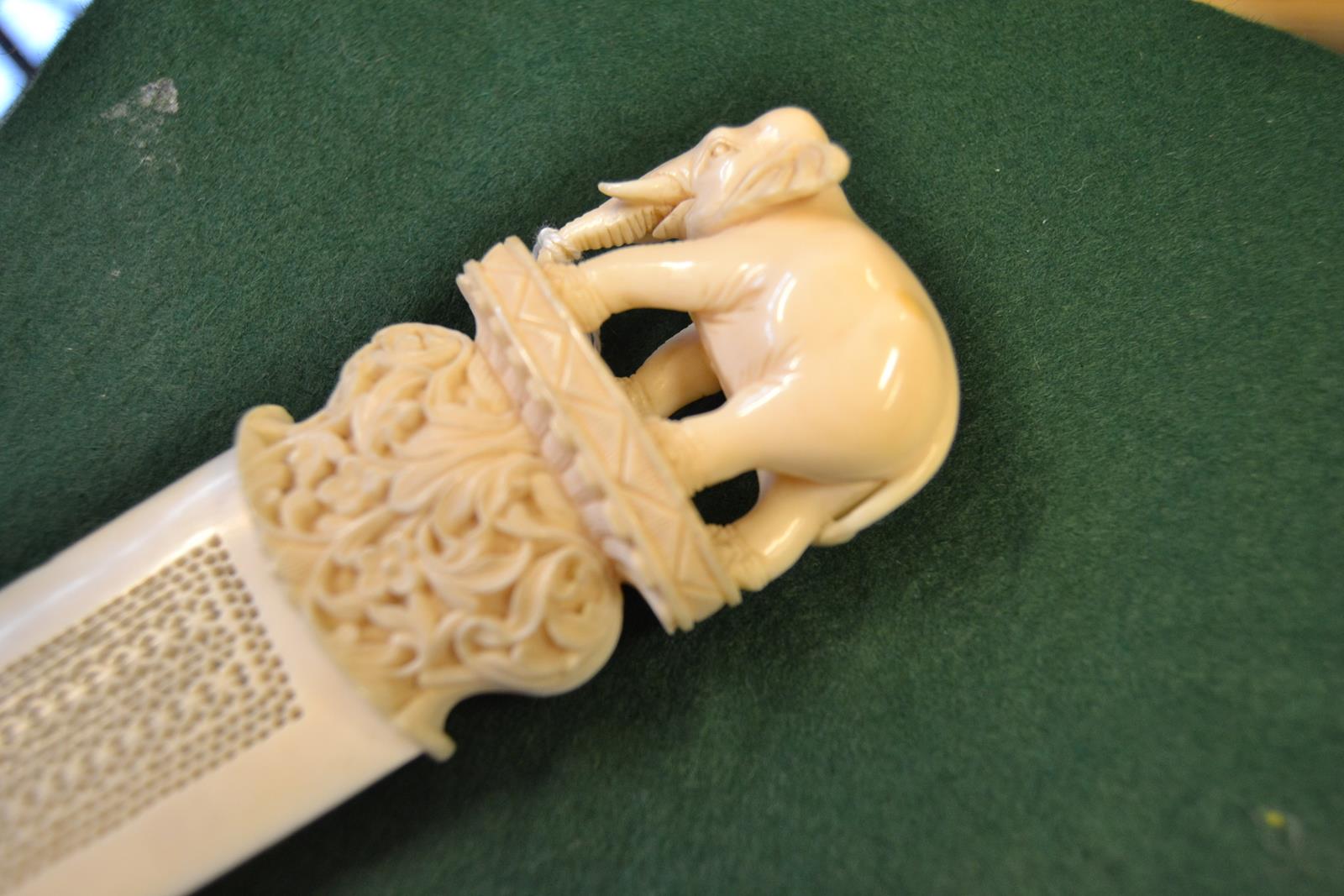 An Indian carved ivory paper knife, elephant surmount, pierced blade