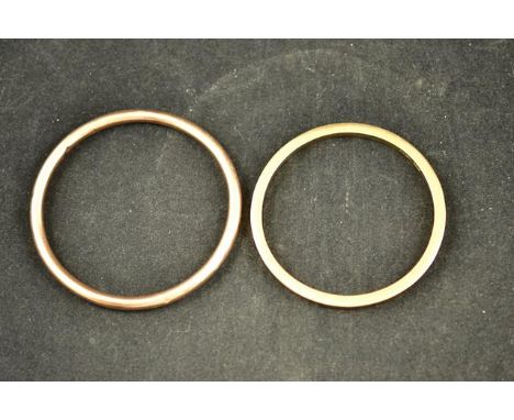 A 9ct rose gold bangle of tubular form - diam 9cm, together with another 9ct gold bangle - diam 8.2cm - approx total weight 2