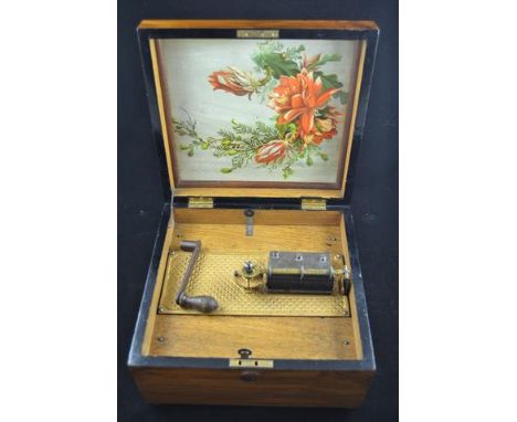A Kalliope musical disc box, floral print to interior of lid, winding handle, one tooth broken, with one original and one rep