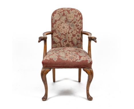 A 20th century Georgian-style walnut-framed open armchair With a floral tapestry upholstered back and overstuffed seat betwee