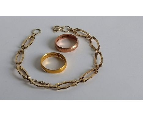A 22ct gold wedding band, size I, 2.63g, another 9ct, size K and a 9ct gold link bracelet, 18 cm, both 4.3g, all hallmarked (