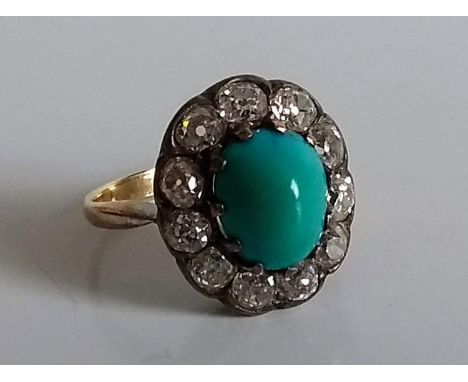 A turquoise and diamond cluster ring in a white and yellow metal setting, size K, oval cabochon 10mm x 8mm, 4.43g 
