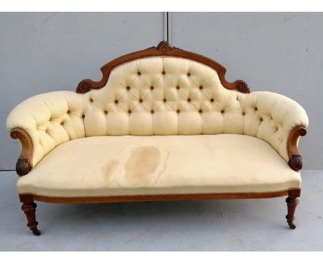 A Victorian walnut-framed sofa with arched support, string inlay and marquetry decoration, button back upholstery on turned l