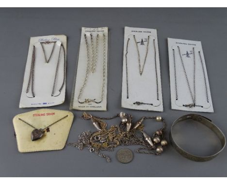 Silver bangle, locket on chain and four sterling silver necklaces in original packaging, a vintage sixpence with a small quan