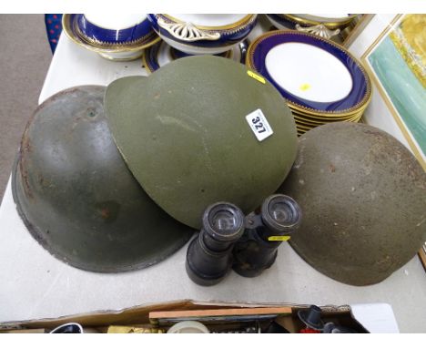 Two steel military helmets and one other and a pair of vintage field binoculars
