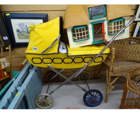 Child's vintage toy pram and a toy thatched roof cottage