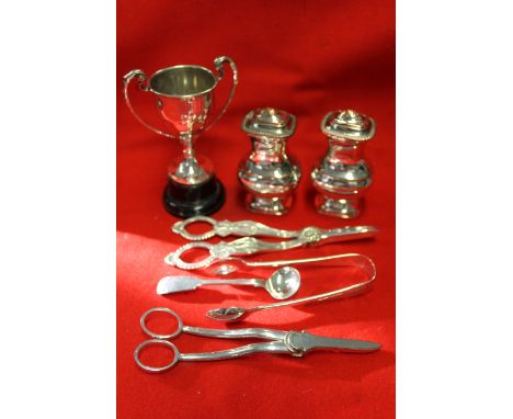 A collection of silver plated wares, includes chamber stick with snuffer, pair of peppers, two grape scissors, sugar tongs, c